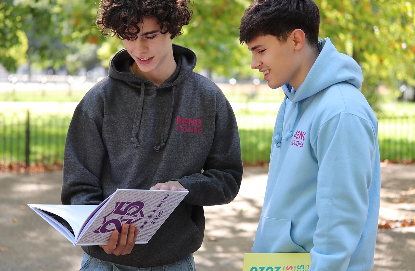 Students holding yearbooks and hoodies